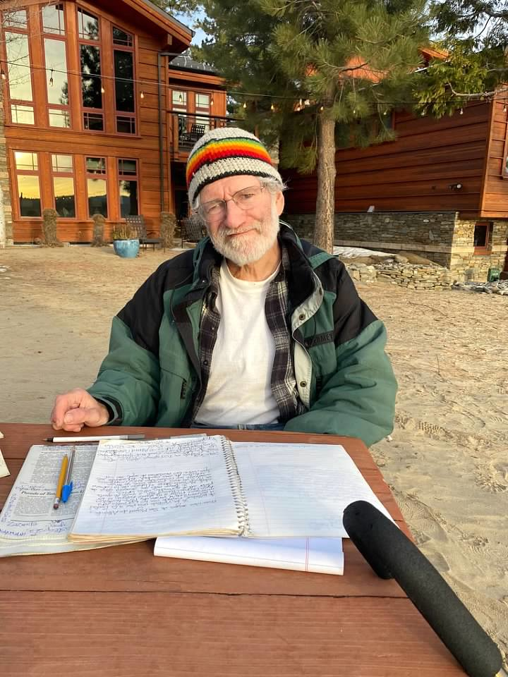Eric with his notebook at a beach table